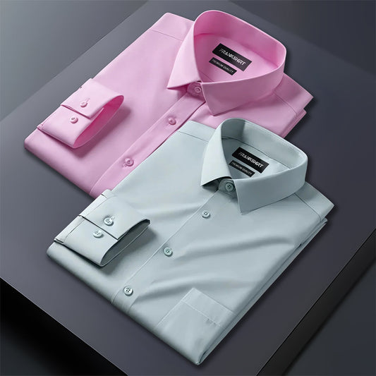 Two folded dress shirts, one pink and one light blue, on a dark surface.