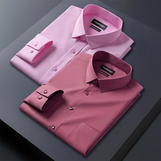 Two folded pink dress shirts on a dark surface with a visible brand label.