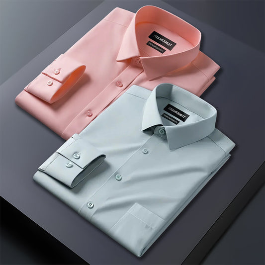 Two folded dress shirts, one pink and one light blue, on a dark surface.